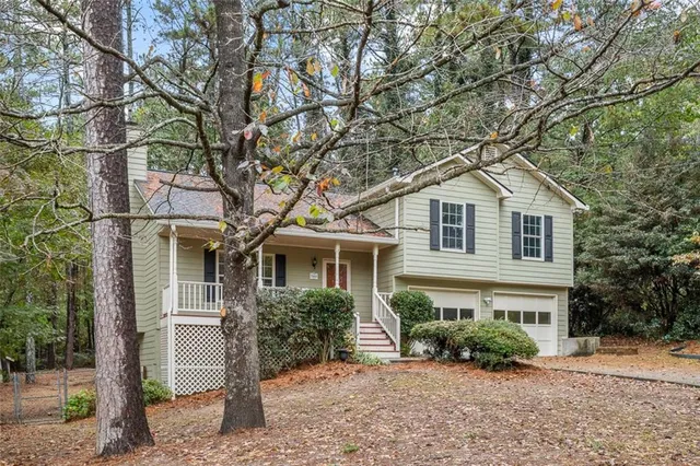 a front view of a house with a yard and potted plants