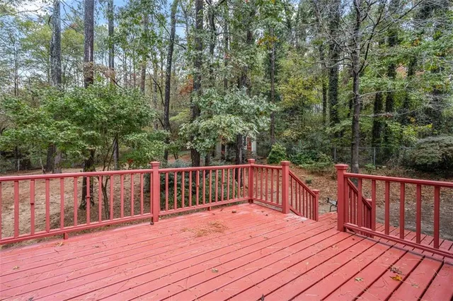 a balcony with wooden floor and trees in the back