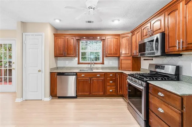 a kitchen with stainless steel appliances granite countertop a stove sink and microwave