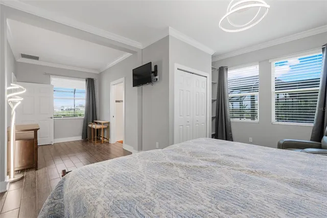 a bedroom with a large bed and a flat tv screen on dresser