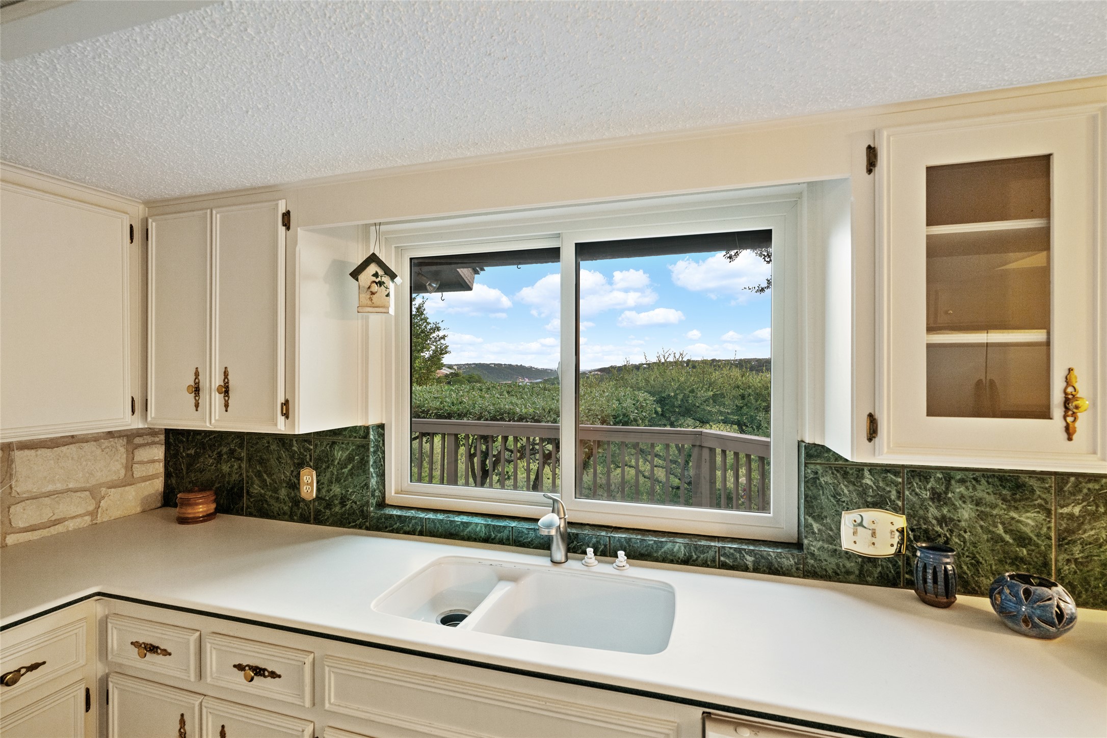 5319 Musket Ridge Austin, TX 78759 - Photo 14 of 39 A well-lit kitchen boasts ample counter space, rich green backsplash, and an impressive verdant outlook.