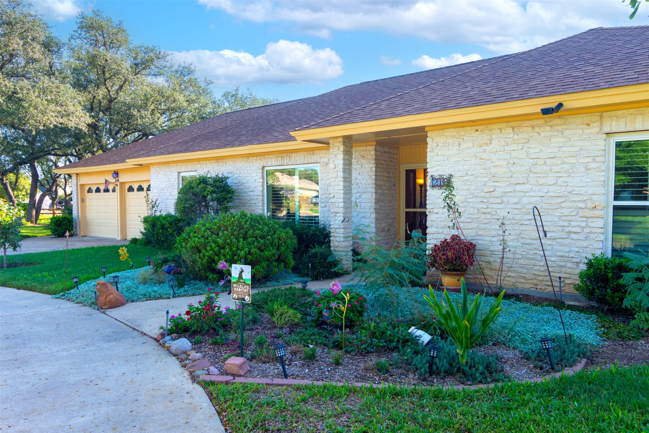 219 Turtle Bend Georgetown, TX 78628 - Photo 3 of 37 A classic stone exterior meets neatly landscaped garden beds.
