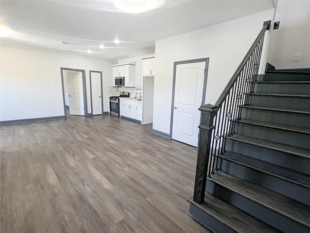 a view of a kitchen with wooden floor and electronic appliances