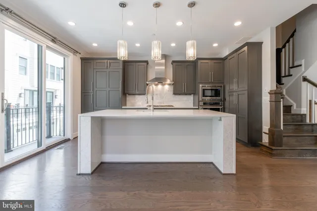 a kitchen with stainless steel appliances granite countertop a sink a stove and a refrigerator