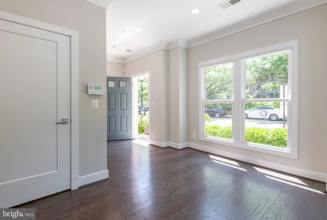an empty room with wooden floor and stairs