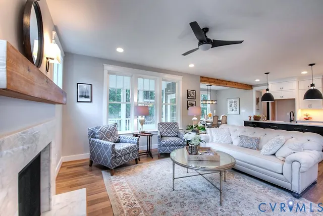a living room with furniture a fireplace and a large window