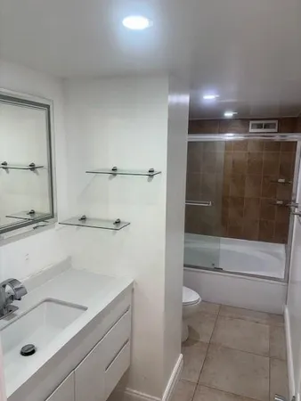 a kitchen with stainless steel appliances granite countertop a refrigerator a stove a sink and a microwave