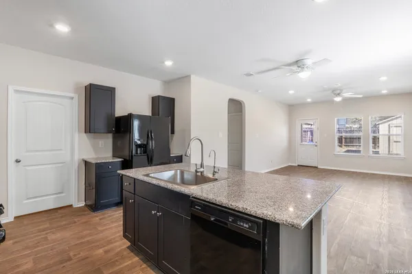 a kitchen with stainless steel appliances granite countertop a sink and a refrigerator