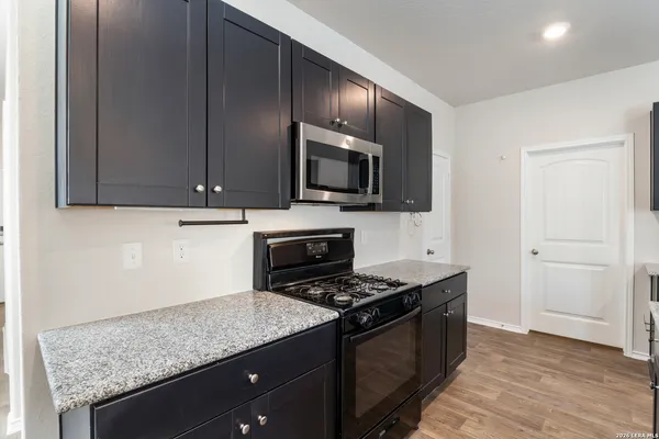a kitchen with granite countertop wooden cabinets and stainless steel appliances
