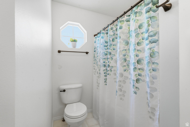 99 Penhurst Place Logan, UT 84341 - Photo 21 of 34 Bathroom featuring an octagonal window, white toilet, and bronze-finish fixtures