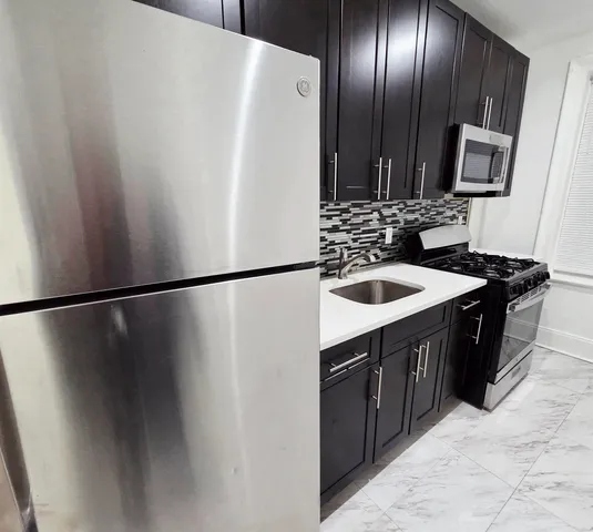 a kitchen with stainless steel appliances a refrigerator and a sink