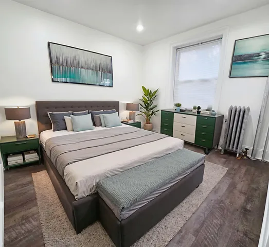 a bedroom with a bed and painting on the wall