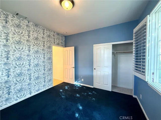 a view of a room with kitchen island stainless steel appliances wooden floor and window