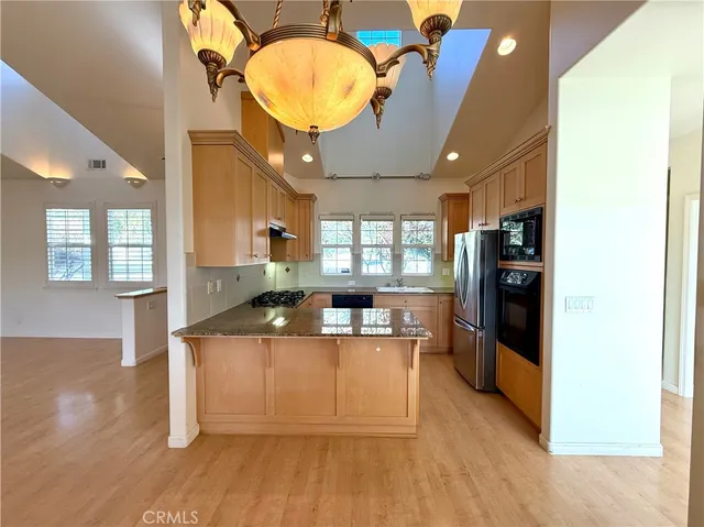 a kitchen with stainless steel appliances granite countertop a stove a sink and a refrigerator