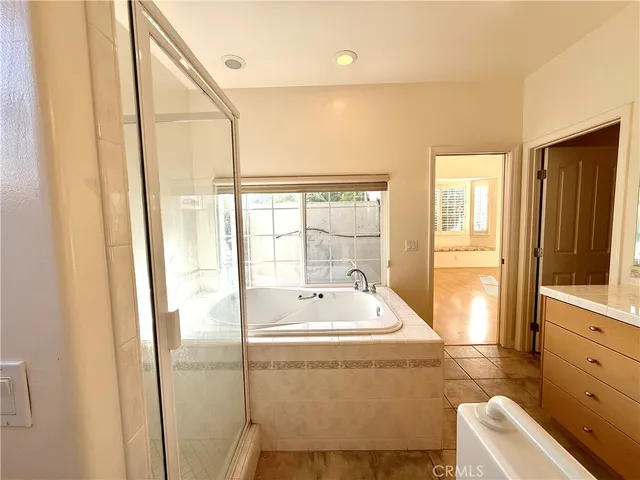 a bathroom with a granite countertop toilet a sink and a glass door