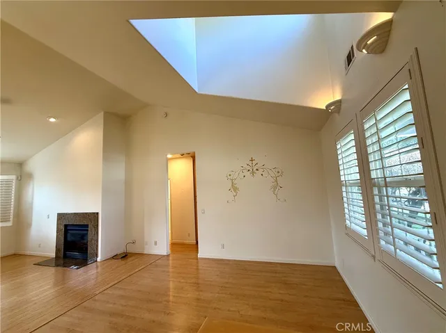 a view of an empty room with a fireplace and a window