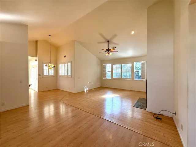 a view of an empty room with window and wooden floor