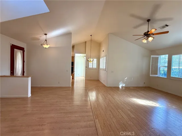 a view of an empty room with window and wooden floor