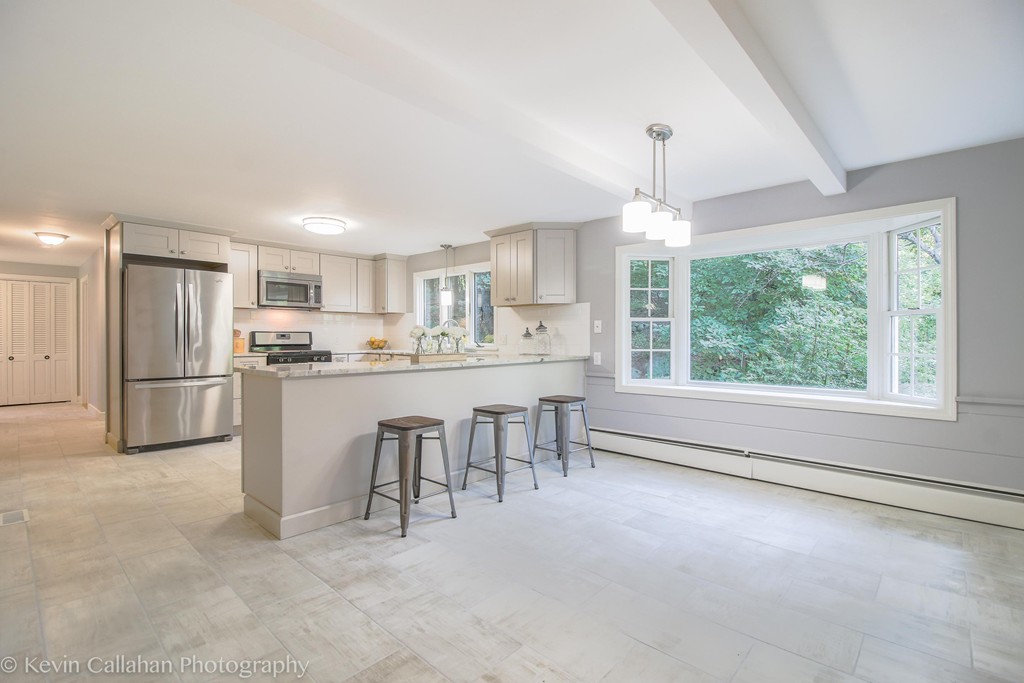 14 Pine Hill Road Framingham, MA 01701 - Photo 10 of 26 a kitchen with kitchen island a stove a sink a refrigerator and a dining table