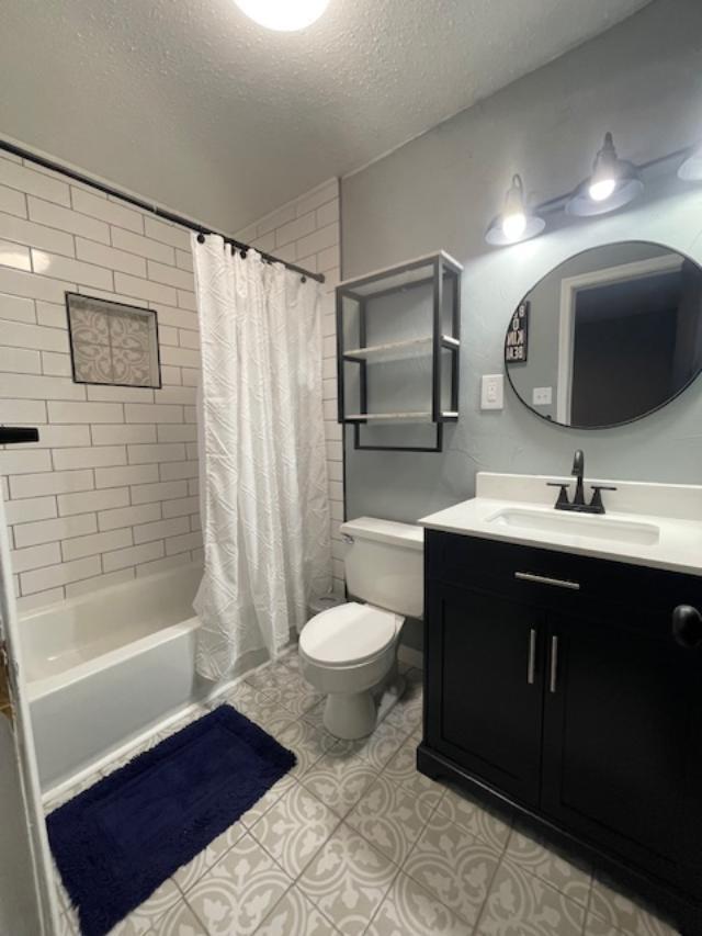 5611 16th Place Lubbock, TX 79416 - Photo 15 of 17 a bathroom with a sink toilet a mirror and shower
