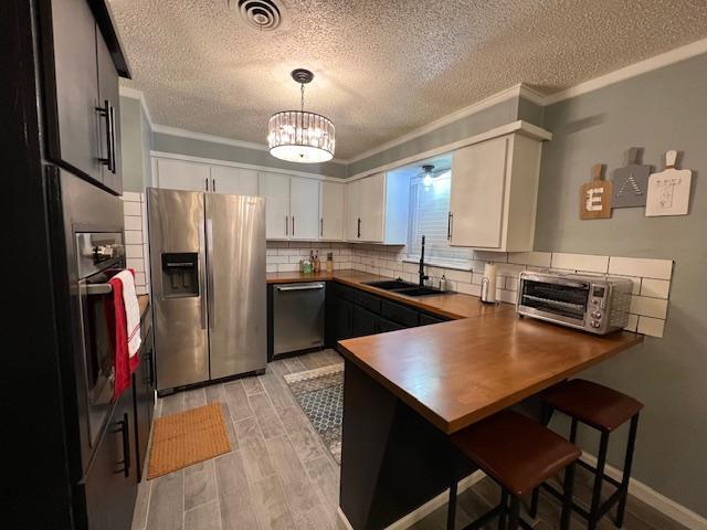 5611 16th Place Lubbock, TX 79416 - Photo 7 of 17 a kitchen with stainless steel appliances a table chairs and refrigerator