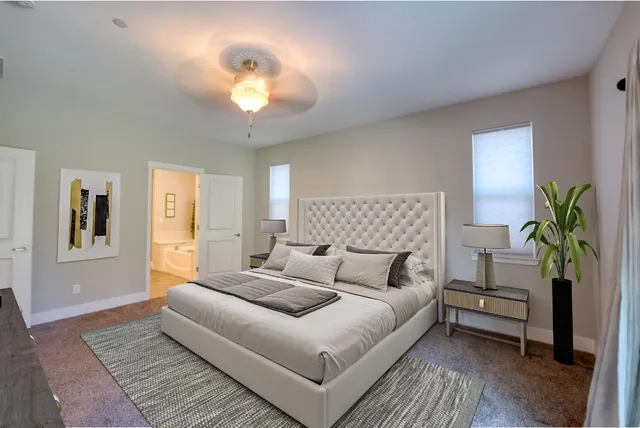 a view of a hallway with wooden floor and a bathroom