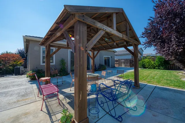 a view of a chair and tables in the patio with a small yard