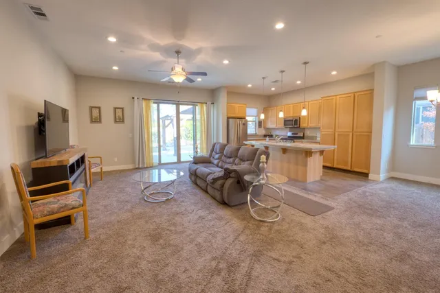 a living room with furniture a flat screen tv and a large window