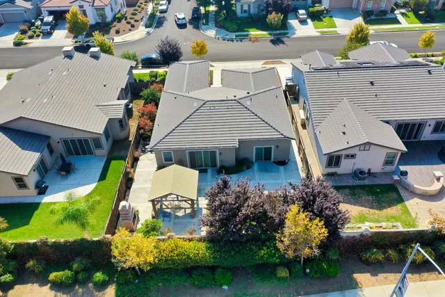 an aerial view of a house with swimming pool and outdoor seating