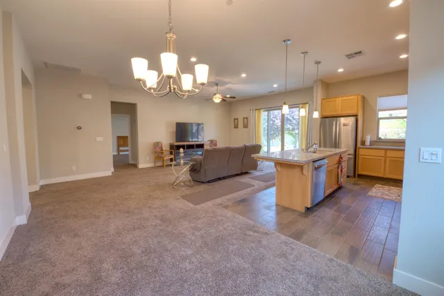 a kitchen with a sink a counter top space and a view of living room