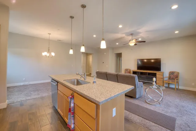 a large kitchen with kitchen island a large counter top space a sink stainless steel appliances and cabinets