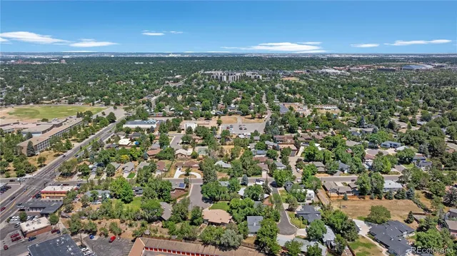 an aerial view of residential houses with outdoor space and trees