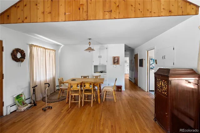a dining room with furniture and wooden floor