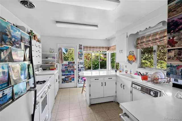 a kitchen that has a lot of cabinets in it and wooden floor