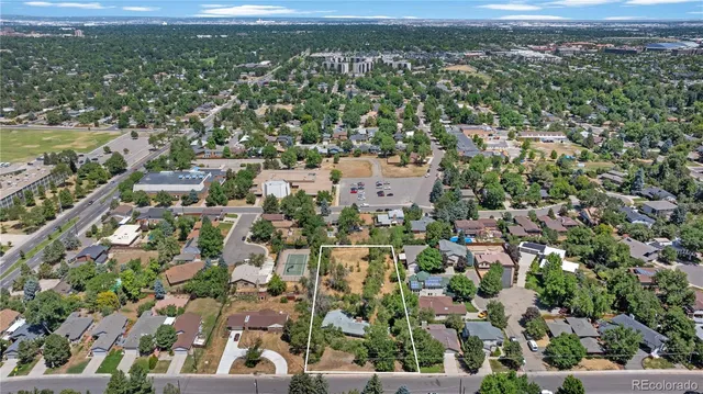 an aerial view of residential houses with outdoor space and trees