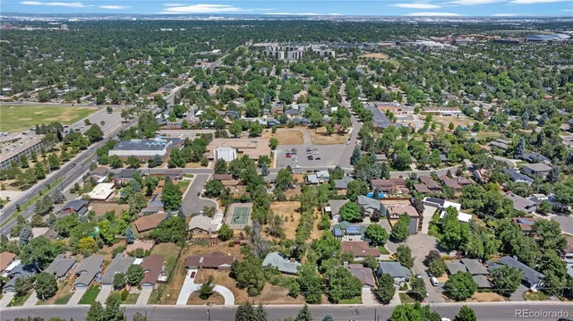 an aerial view of residential houses with outdoor space and trees