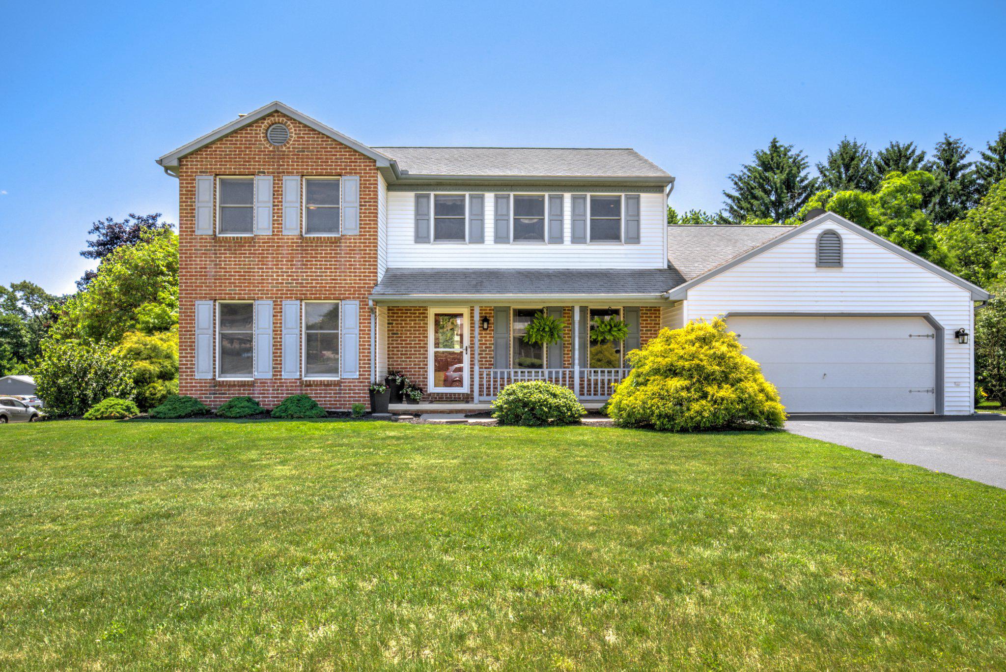 Charming brick home with lush greenery.