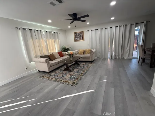 a living room with furniture and a ceiling fan