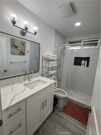a bathroom with a double vanity sink toilet and shower