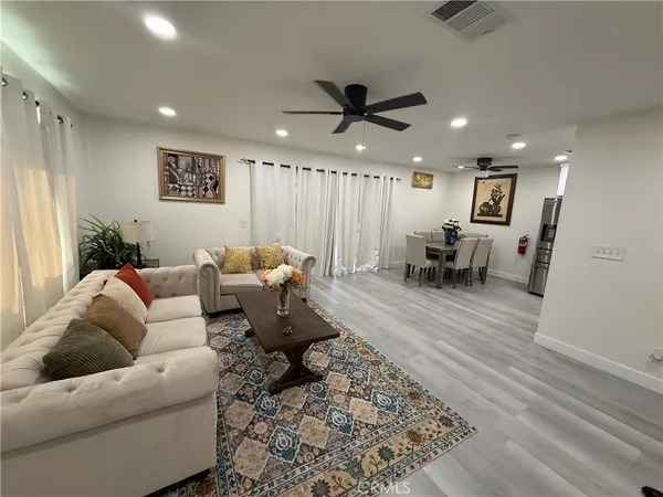 a living room with furniture and a wooden floor