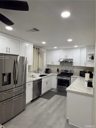 a kitchen with stainless steel appliances and white cabinets