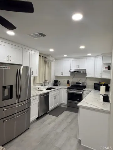 a kitchen with stainless steel appliances and white cabinets