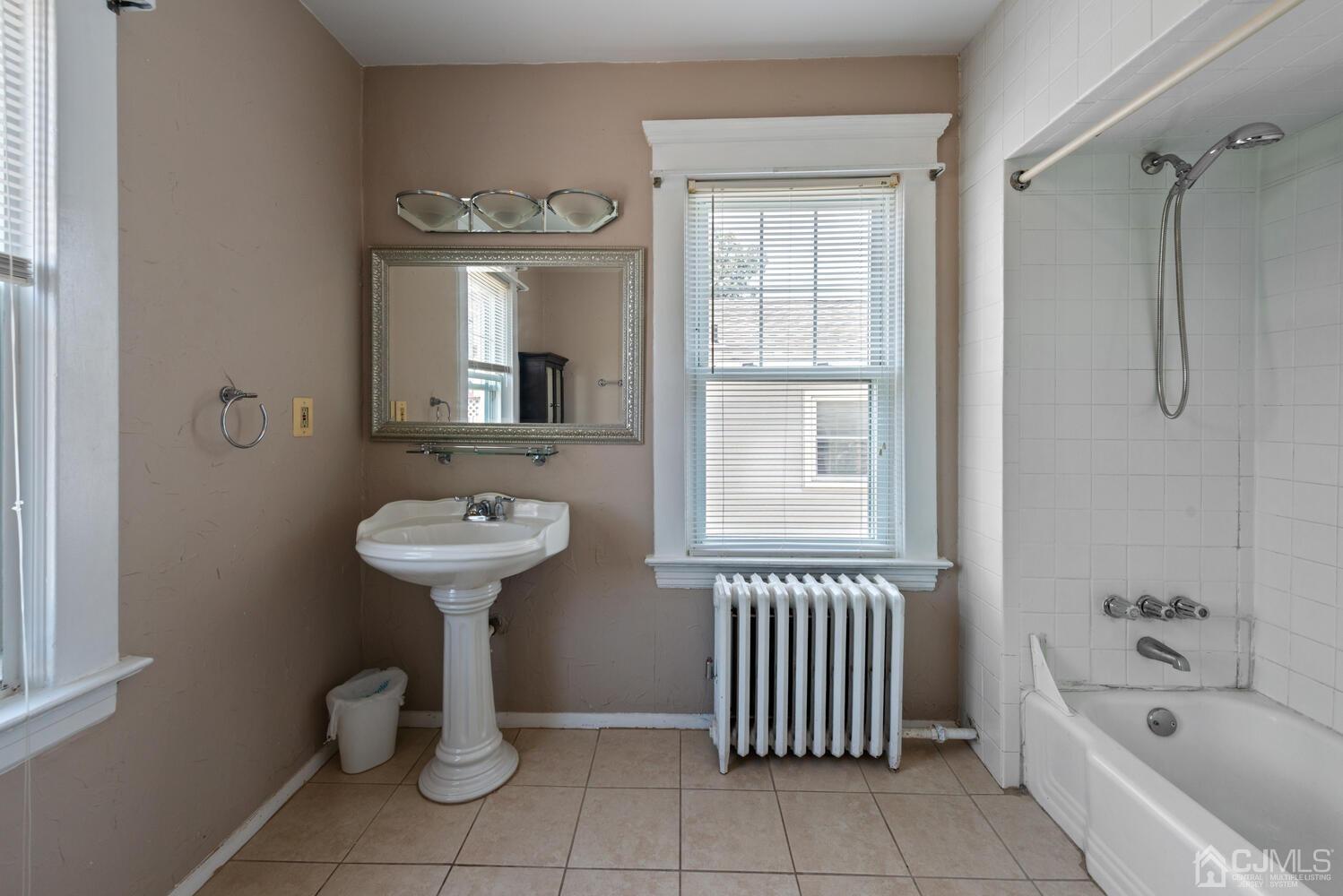 210 Rector Street Perth Amboy, NJ 08861 - Photo 20 of 24 a bathroom with a sink a mirror and a bathtub