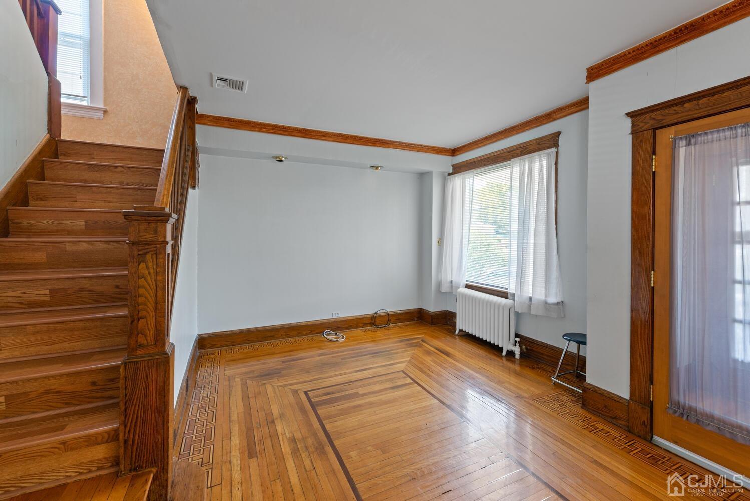 210 Rector Street Perth Amboy, NJ 08861 - Photo 3 of 24 a view of an empty room with wooden floor and a window