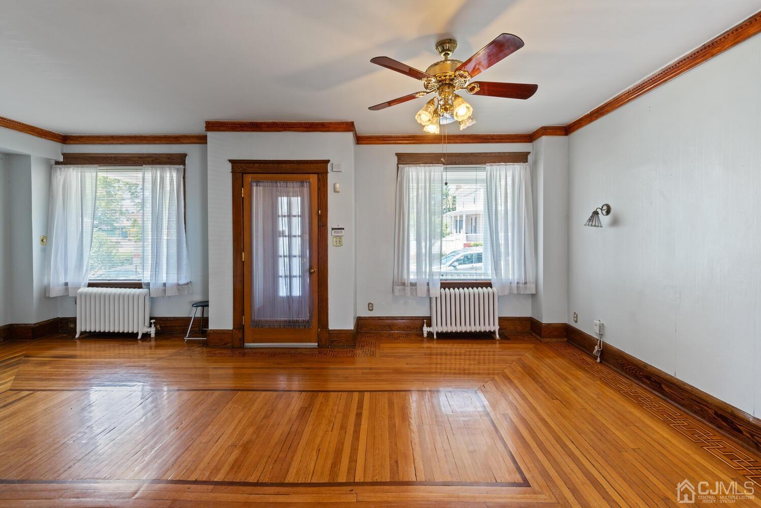 210 Rector Street Perth Amboy, NJ 08861 - Photo 4 of 24 a view of an empty room with window and wooden floor