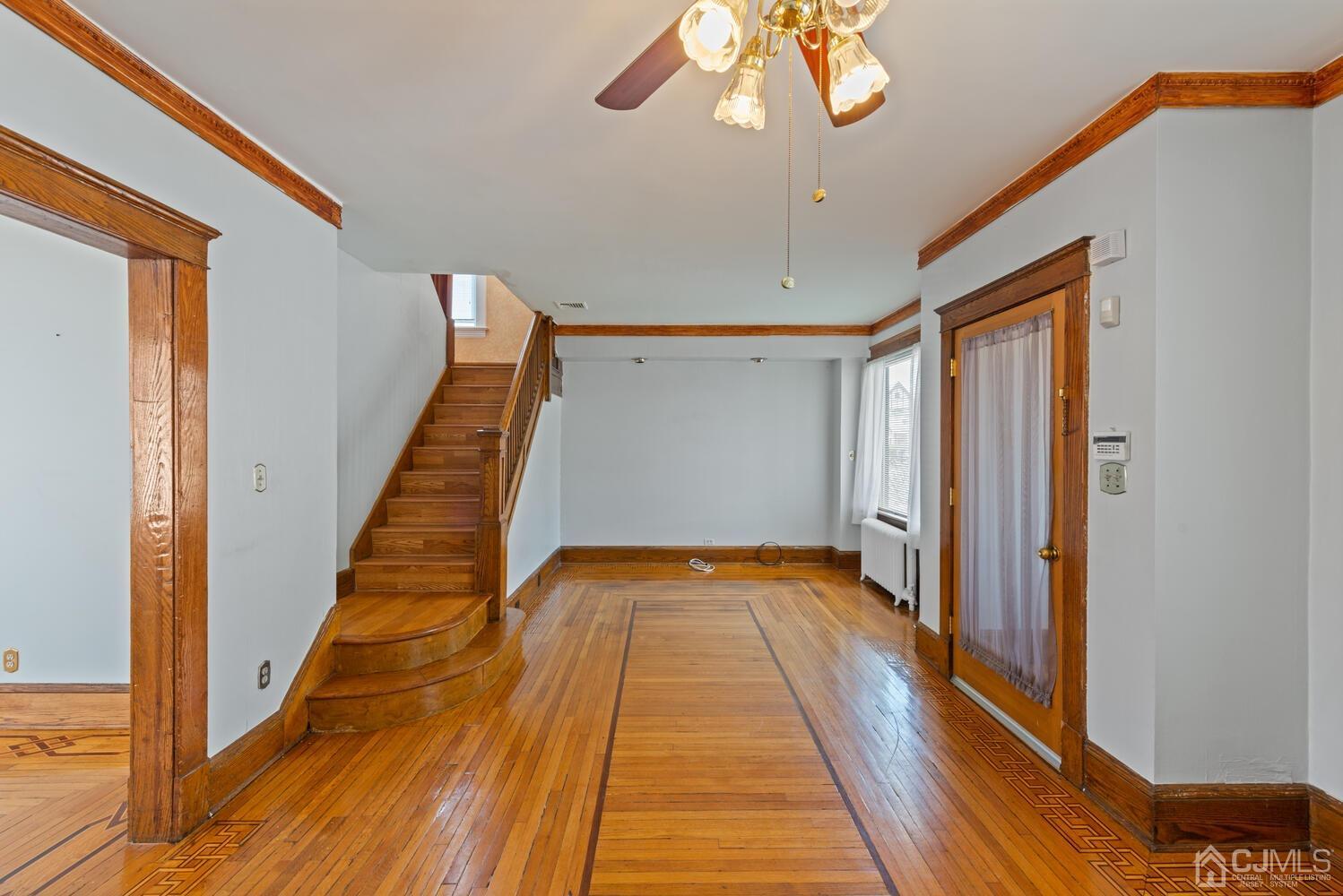 210 Rector Street Perth Amboy, NJ 08861 - Photo 6 of 24 a view of a hallway with wooden floor and staircase