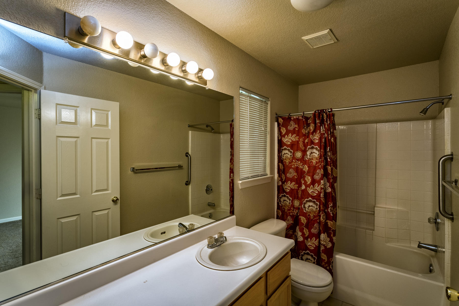 3339 Lawrence Road Redding, CA 96002 - Photo 13 of 18 a bathroom with a sink a toilet a mirror and shower