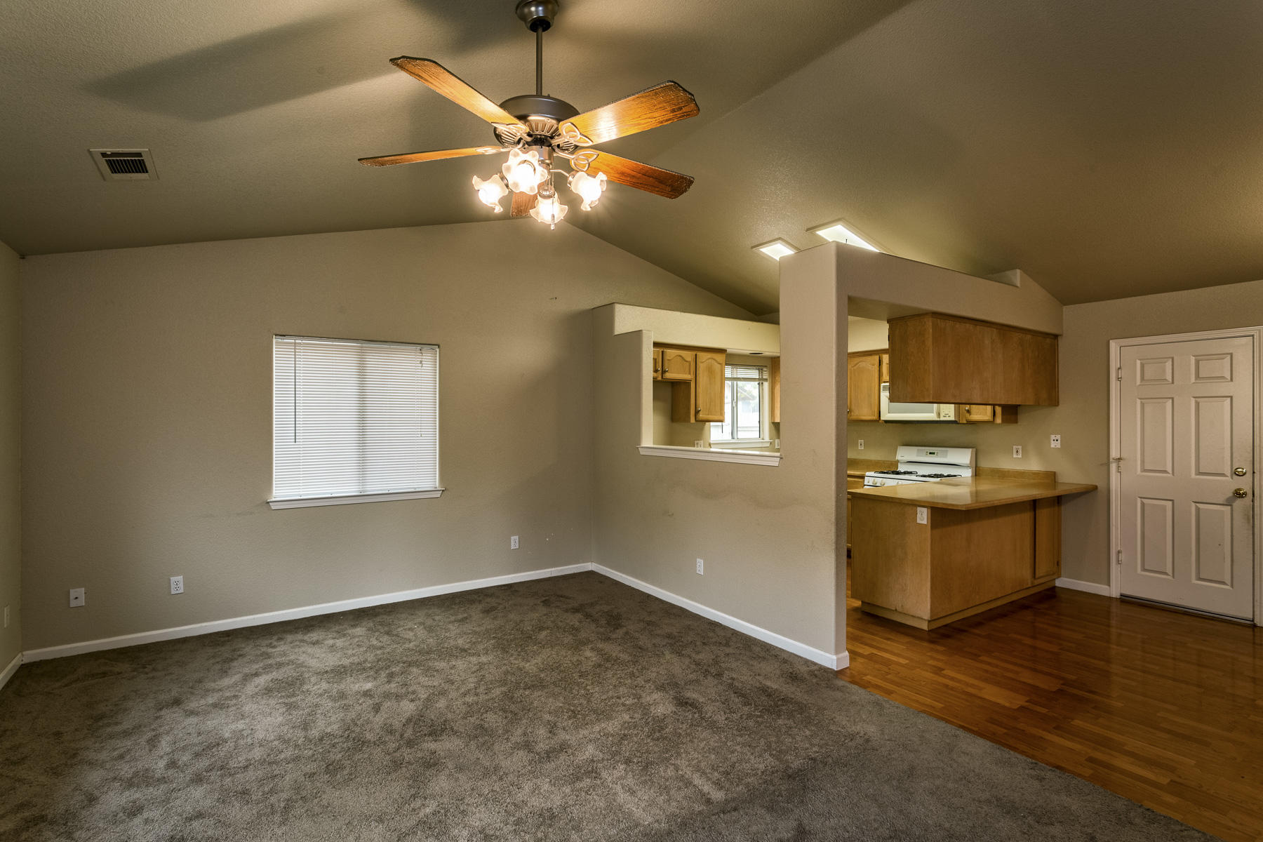 3339 Lawrence Road Redding, CA 96002 - Photo 6 of 18 a view of a kitchen with a stove cabinets wooden floor and a ceiling fan