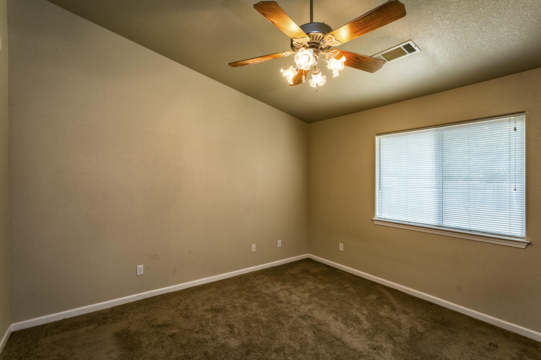 3339 Lawrence Road Redding, CA 96002 - Photo 9 of 18 an empty room with a chandelier fan and windows