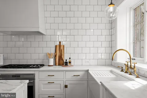 a bathroom with a granite countertop shower a sink and a window